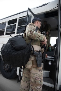 A Utah Air National Guard Airman boards a bus on their way to  downtown Salt Lake City, Utah