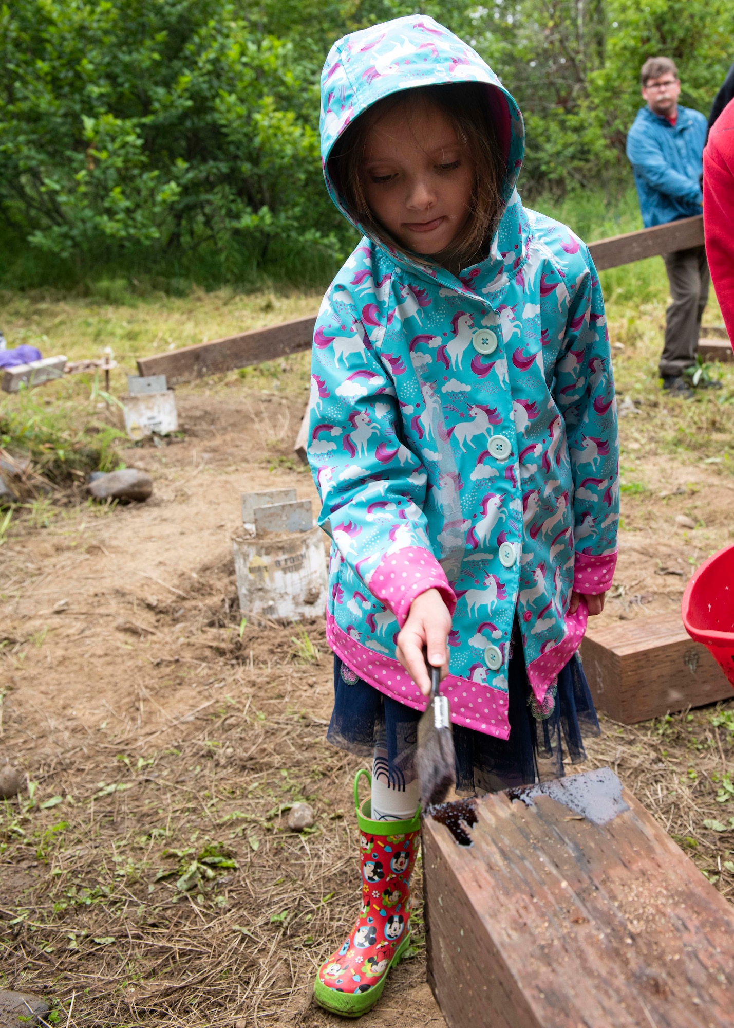 The daughter of U.S. Air Force Lt. Col. Pamela Boyarski, 962nd Airborne Air Control Squadron commander, paints a wood beam at Joint Base Elmendorf-Richardson, Alaska, Aug. 8, 2020. Daryn Moore, a member of Scouts BSA Troop 54, built a pavilion with help from other Scouts and members of the 962nd Airborne Air Control Squadron to protect the memory box and cross at the Yukla 27 crash site from rain and snow. The pavilion is Moore’s Eagle Scout Service Project, a project that benefits the community as a requirement to gain the rank of Eagle Scout, the highest rank in Scouting.