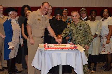 Capt. Harold Cole, left, commanding officer of Navy Cyber Defense Operations Command (NCDOC) and Vice Adm. Brian Brown, right, commander of Naval Information Forces (NAVIFOR) celebrate a Women's Heritage Month event with a cake cutting ceremony.