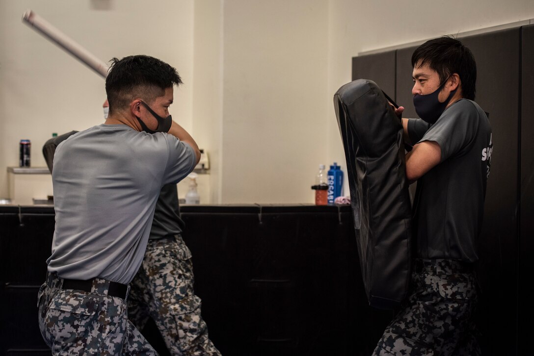 A Koku-Jieitai member (Japan Air Self-Defense Force) performs a baton strike during the bilateral aircraft security training at Yokota Air Base, Japan, August 7, 2020.