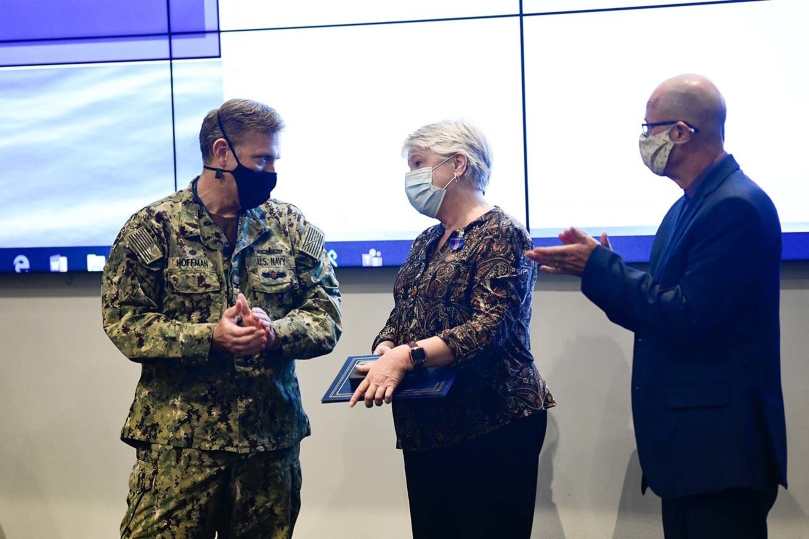 NSWC PHD Commanding Officer Capt. Andrew Hoffman (left) and Technical Director Paul Mann (right) congratulate Air Dominance Department Supportability Manager Janet Mounce on receiving the U.S. Navy Meritorious Civilian Service Award during the command's All Hands event, July 28.