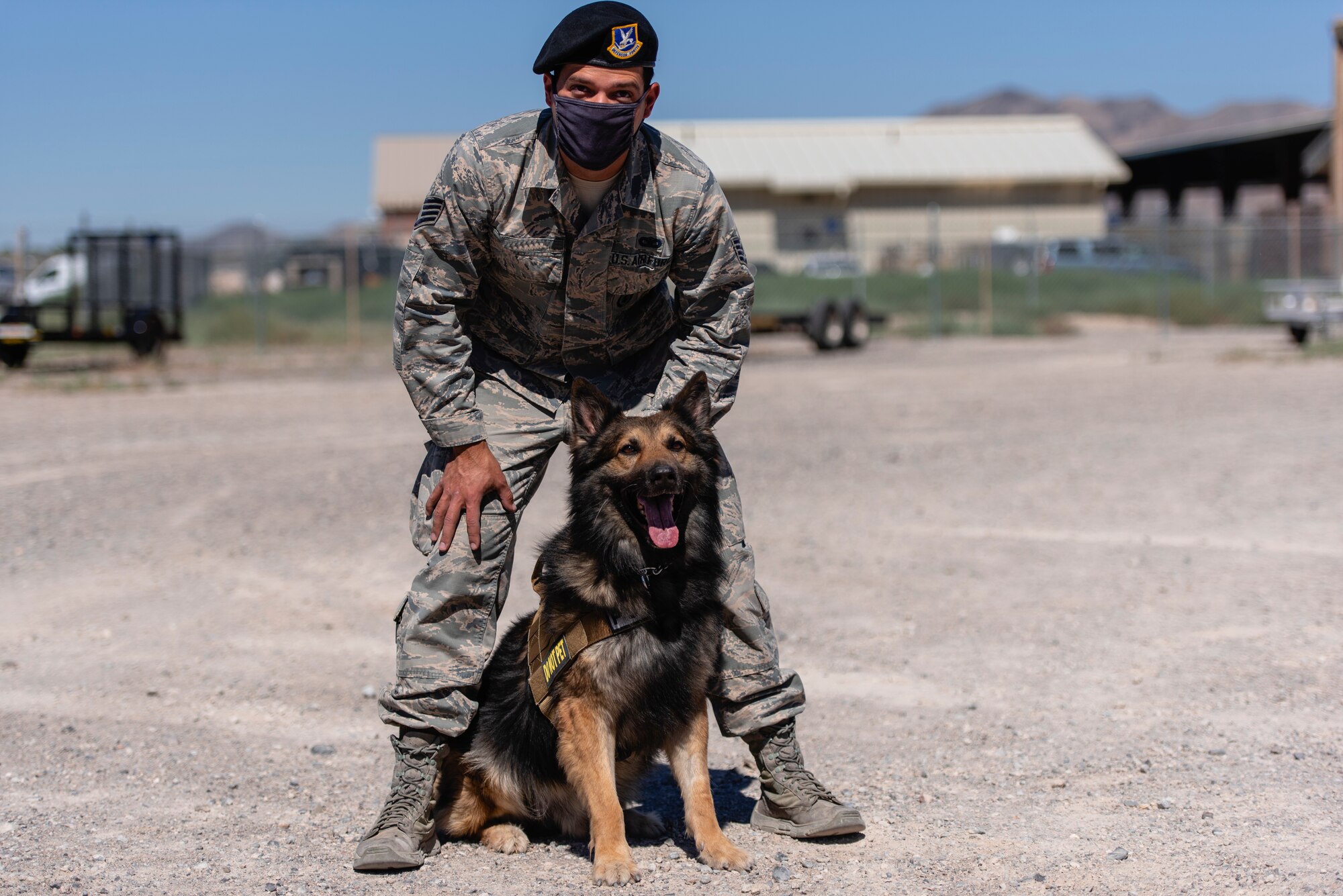 Jojo and his handler pose for a photo in a parking lot.