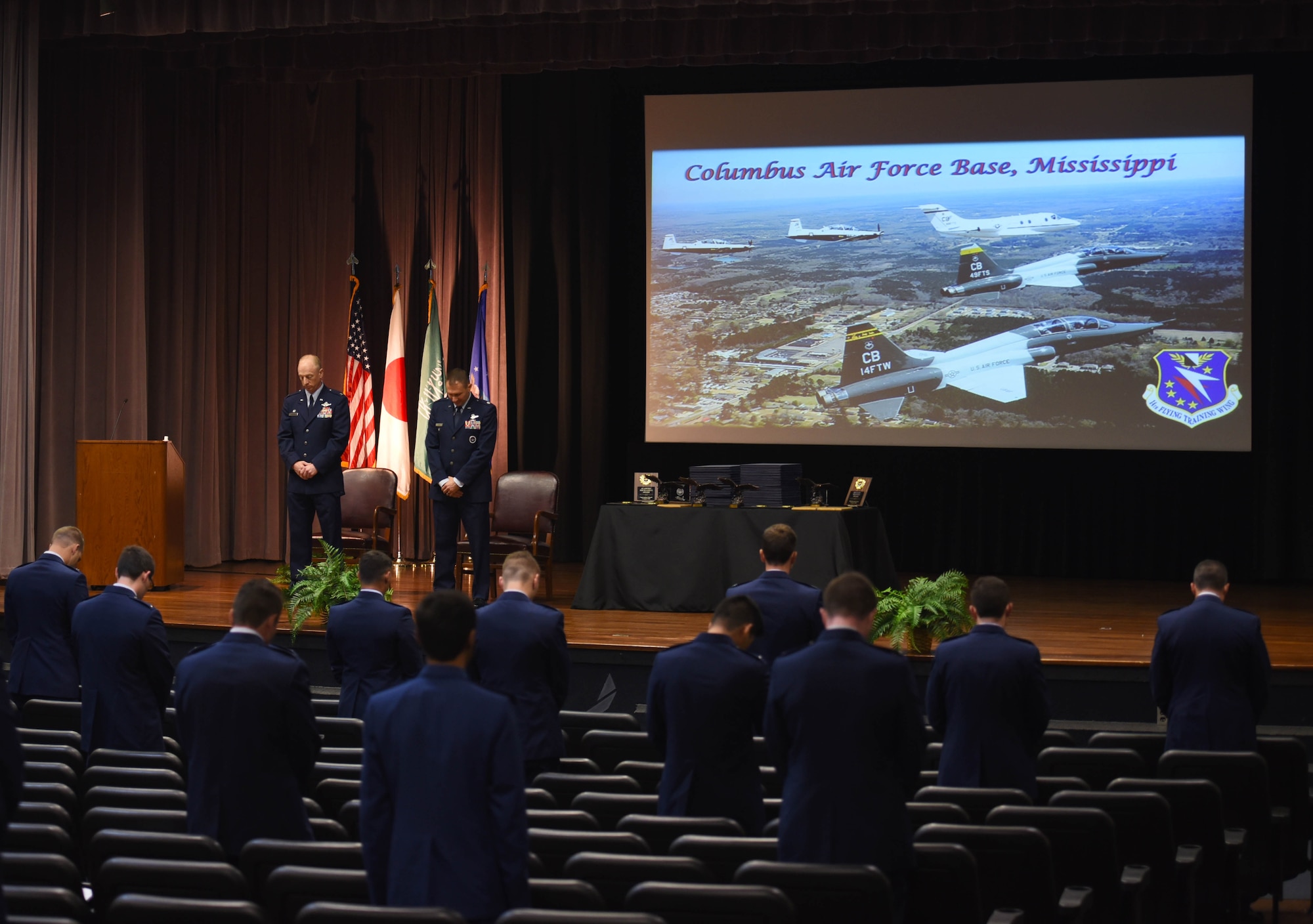 Specialized Undergraduate Pilot Training graduates bow their heads in prayer at a graduation ceremony on August 7, 2020, at Columbus Air Force Base, Miss. Students in the graduating classes maintained their six feet distance in light of the COVID-19 pandemic.  (U.S. Air Force photo by Senior Airman Jake Jacobsen)