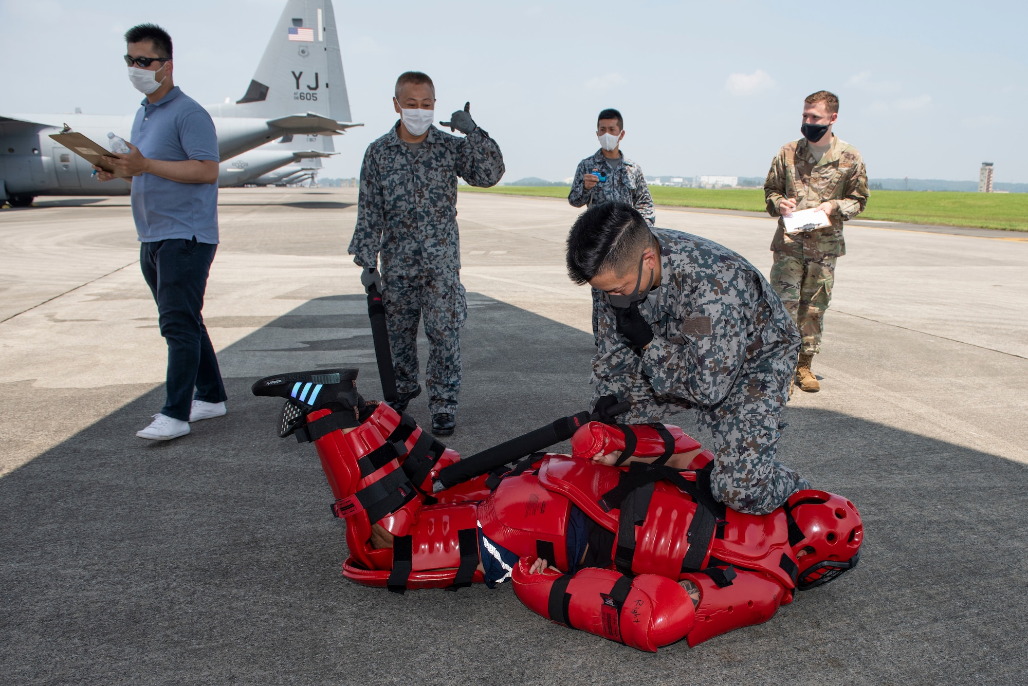 A Koku-Jieitai (Japan Air Self-Defense Force) member apprehends a simulated intruder during a flightline intrusion scenario as a portion of the bilateral aircraft security training at Yokota Air Base, Japan, August 7, 2020.