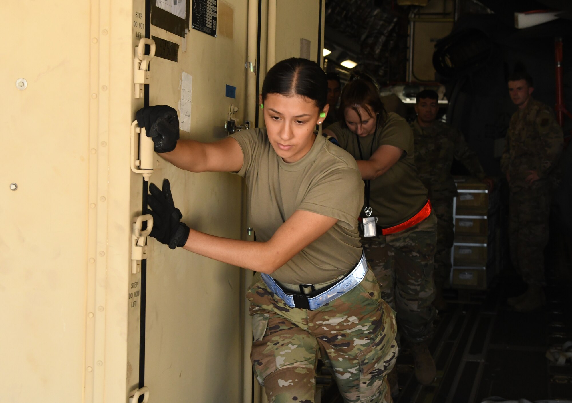 An Airman pushes cargo.