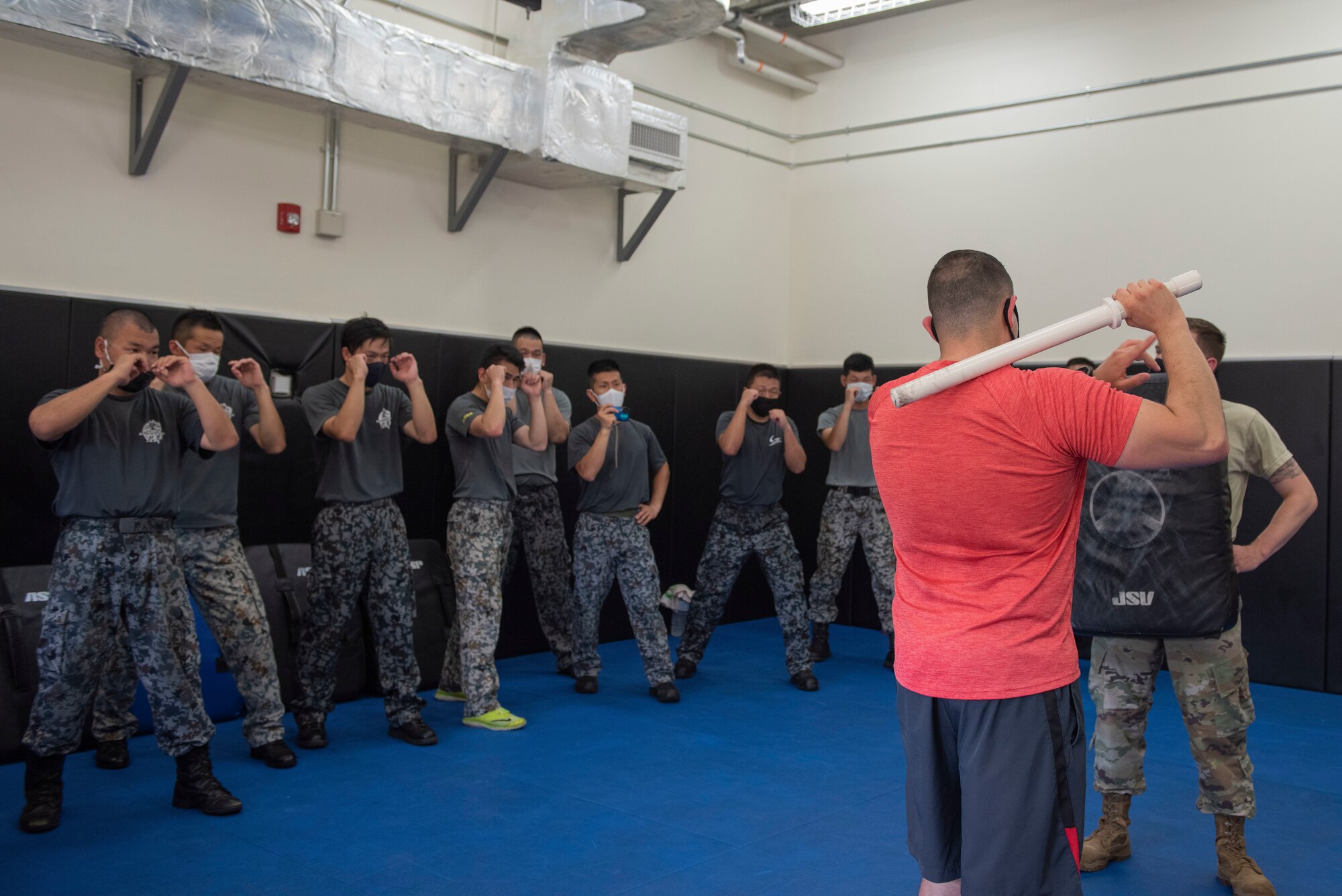 Staff Sgt. Joshua Cordova, 374th Security Forces Squadron flight sergeant, demonstrates a baton technique to Koku-Jieitai (Japan Air Self-Defense Force) members during the bilateral aircraft security training at Yokota Air Base, Japan, August 7, 2020.
