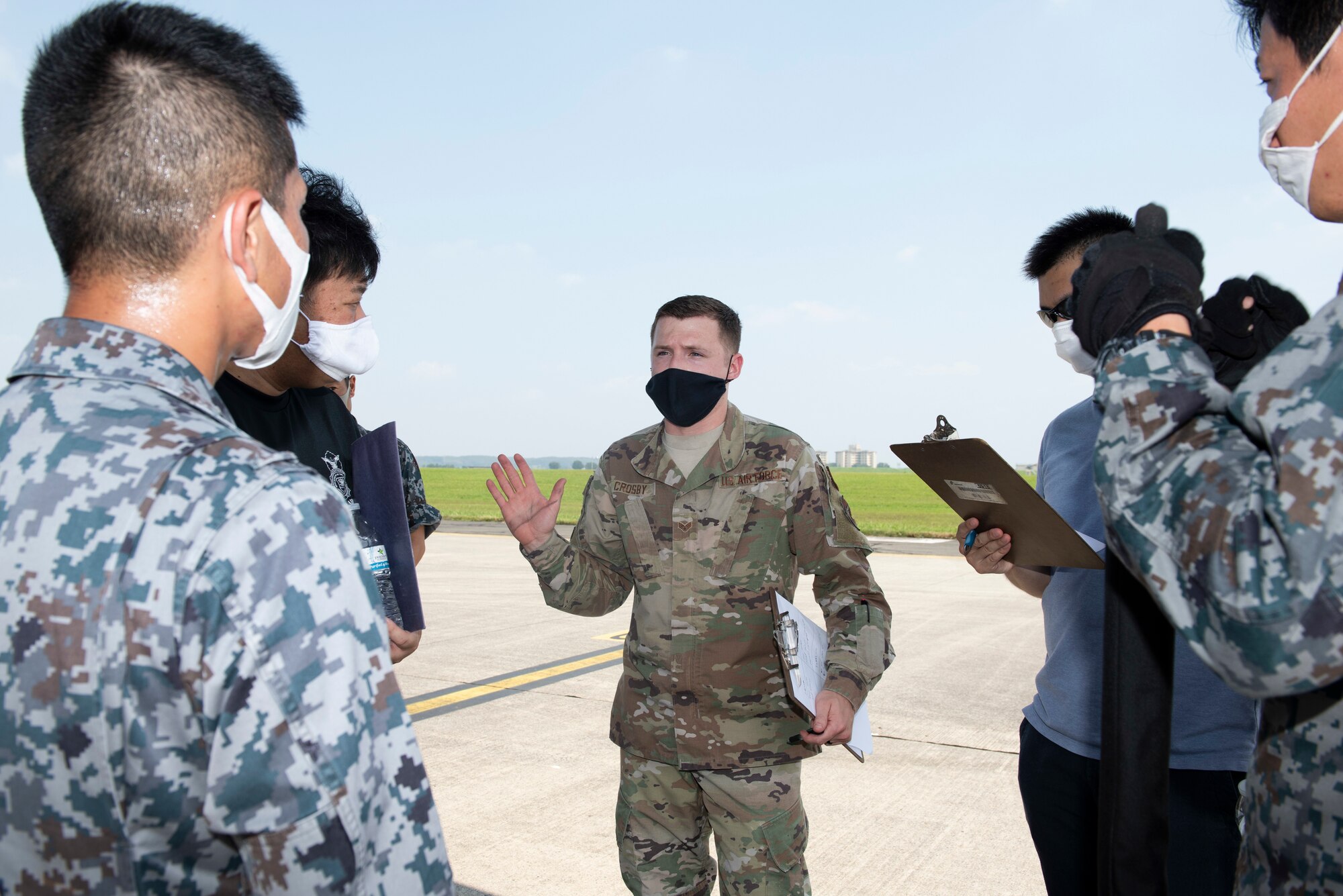 Senior Airman Dylan Crosby, 374th Security Forces Squadron NCO in charge of customs immigration and security team program manager, provides feedback to Koku-Jieitai members (Japan Air Self-Defense Force) after a training scenario during the bilateral aircraft security training at Yokota Air Base, Japan, August 7, 2020.