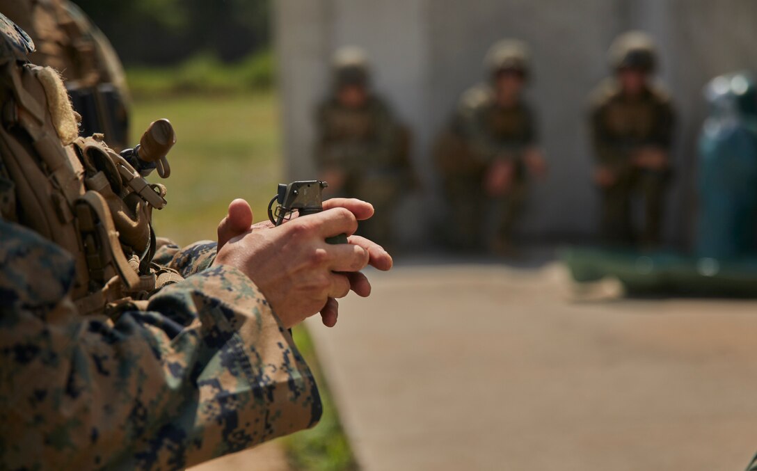 A Marine with Bravo Company, 1st Battalion, 24th Marine Regiment, 4th Marine Division, passes an M67 fragmentation hand grenade during an annual training exercise at Camp Grayling, Mich., Aug. 10, 2020. This training is included in the Marine's annual training and readiness manual, which gives guidance on the equipment, ammunition, ranges and support requirements to plan and execute effective training to increase Marines’ lethality. (U.S. Marine Corps photo by Lance Cpl. Leslie Alcaraz)