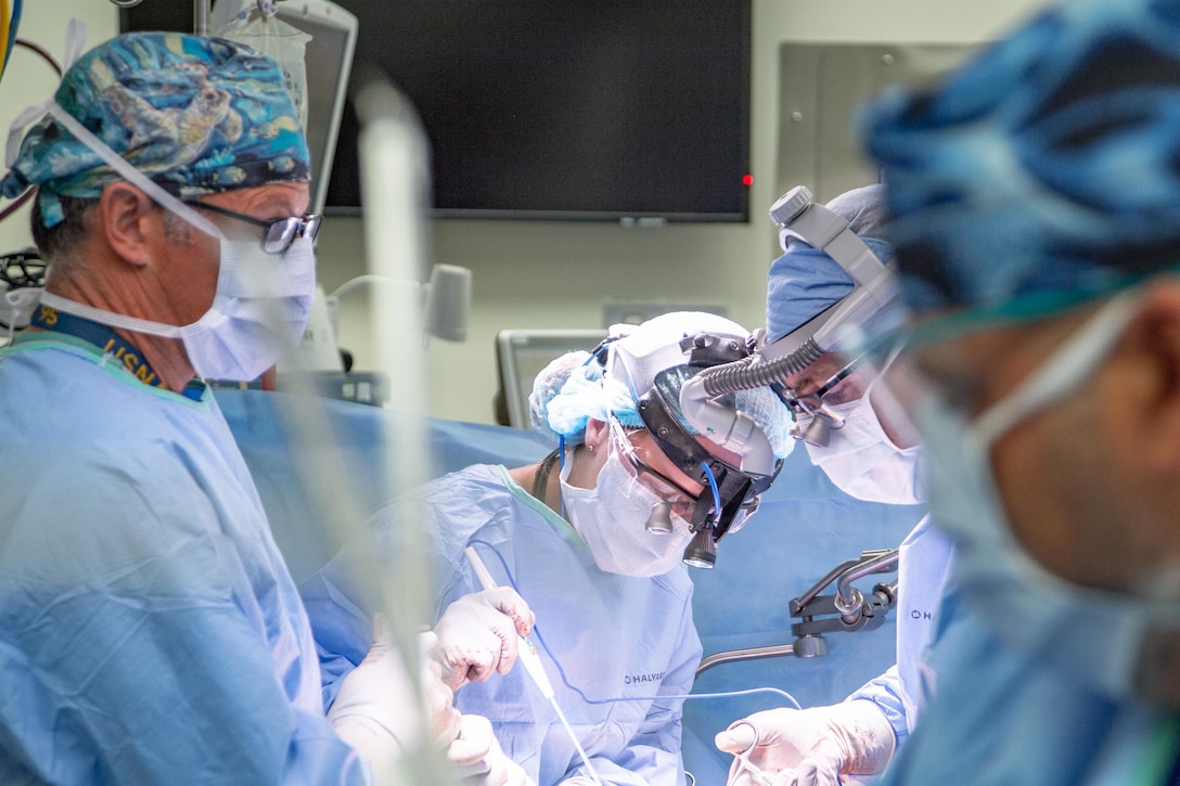 A group of doctors perform surgery on a patient.