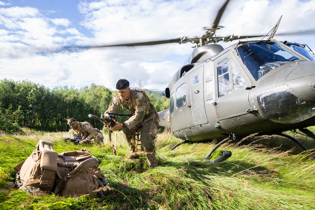 U.S. Marines prepare their weapons after exiting a Norwegian-operated Bell 412 helicopter during Midnight Sun, a battalion force-on-force field exercise in Setermoen, Norway, Aug. 5.