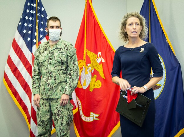 Virginia state Senator Jen Kiggans presents Navy Lieutenant John Miller with a letter of appreciation for his life-saving efforts while on an evening run near his Norfolk residence. (U.S. Navy Photo by Ian Delossantos/Released)