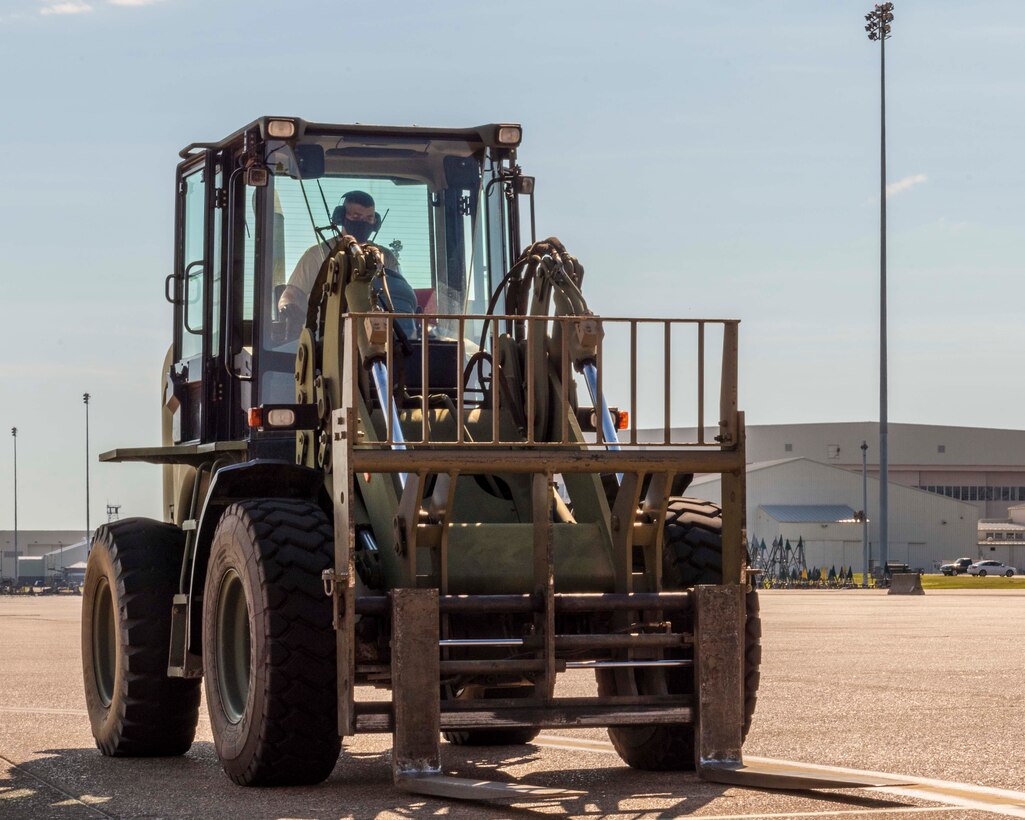 Reserve member of the 96th Aerial Port Squadron drives a forklift on the flightline to help load cargo pallets on a C-130J Super Hercules for training Aug. 2, 2020, at Little Rock Air Force Base, Ark. This was the first in-person training event for the 913th Airlift Group since COVID-19 swept across the U.S. Using health precaution measures, reserve members were able to restore readiness while mitigating health risks, ensuring no COVID-19 cases were transmitted among members over the weekend. The majority of our Reserve members have to meet the same requirements of Active Duty personnel. This means they have to balance a fulltime civilian job or college studies while maintaining their military readiness. (U.S. Air Force Reserve photo by Maj. Ashley Walker)