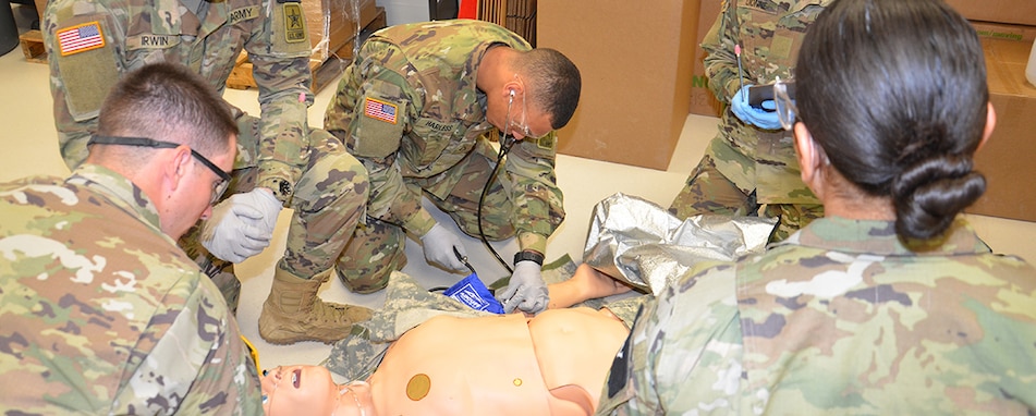 A team of combat medic trainees in the Department of Combat Medic Training program at the Medical Education and Training Campus on JBSA-Fort Sam Houston, attend to a "patient" in the EMT warehouse lab.