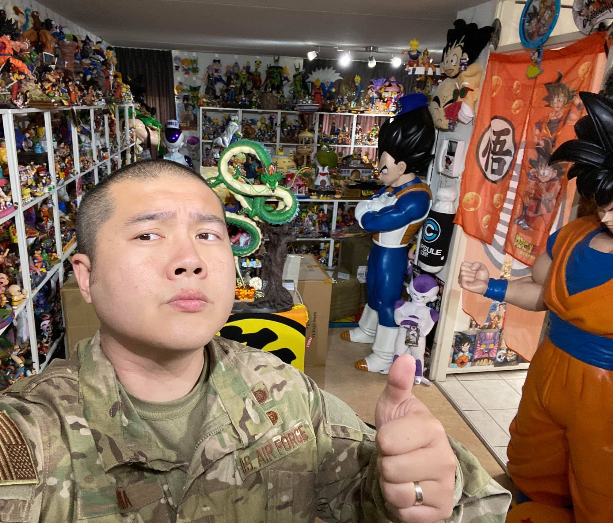 Uniformed servicemember in front of statues.