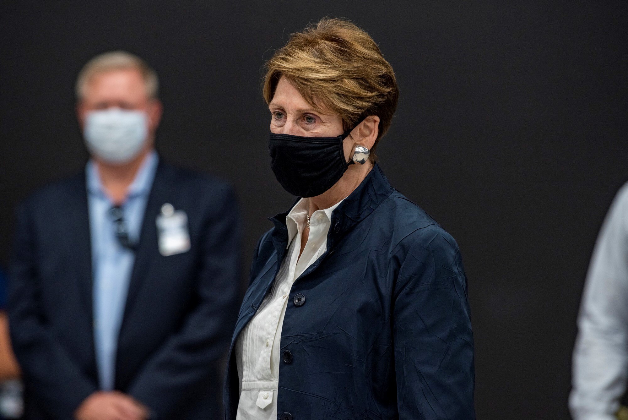 Barbara M. Barrett stands with face mask on.