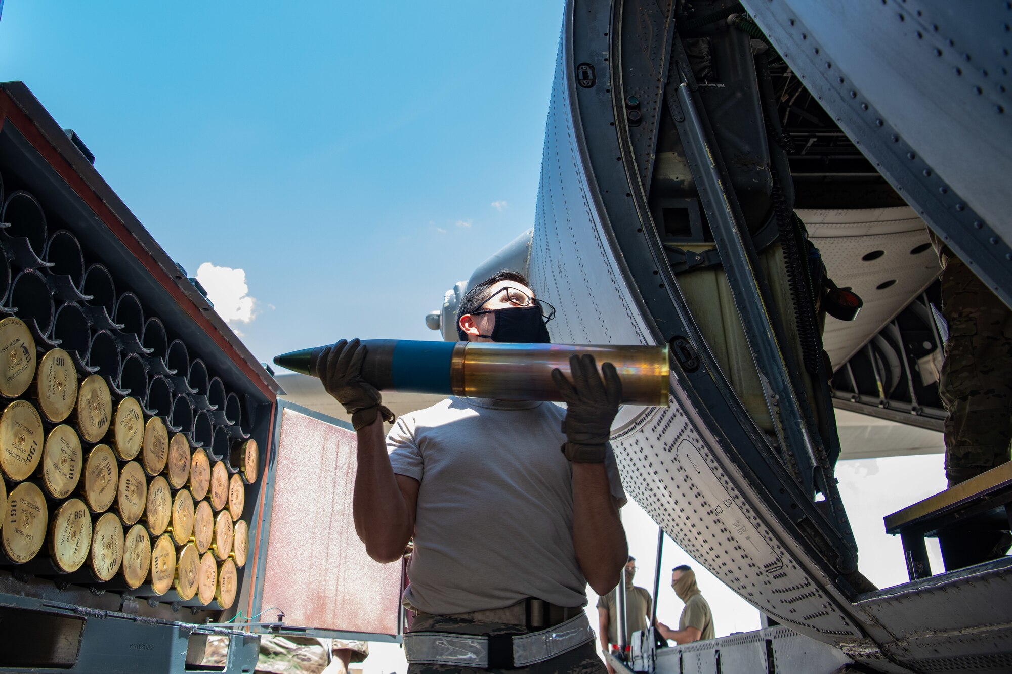 Staff Sgt. Wellington Parraga, a line delivery crew chief assigned to the 27th Special Operations Maintenance Squadron munitions flight, hands off a 105 MM round to a AC-130W Stinger II gunship aircraft’s crew to load for flight configuration prior to a training sortie at Cannon Air Force Base, N.M., July 22, 2020. The 27 SOMXS MUNS flight provides all the munitions needed for the base’s flying units to conduct their combat readiness training. (U.S. Air Force photo by Senior Airman Maxwell Daigle)