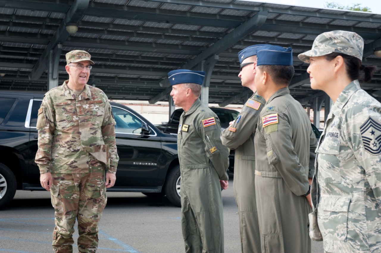 An Air Force general speaks with four airmen.