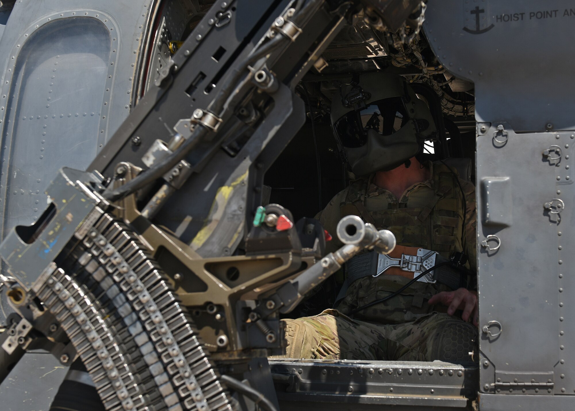 Photo of an Air Force Airman manning the weapons seat of an HH-60G Pavehawk