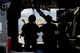 Photo of two Air Force Airmen casting a silhouette behind the side door of an HH-60G Pavehawk on a military flightline