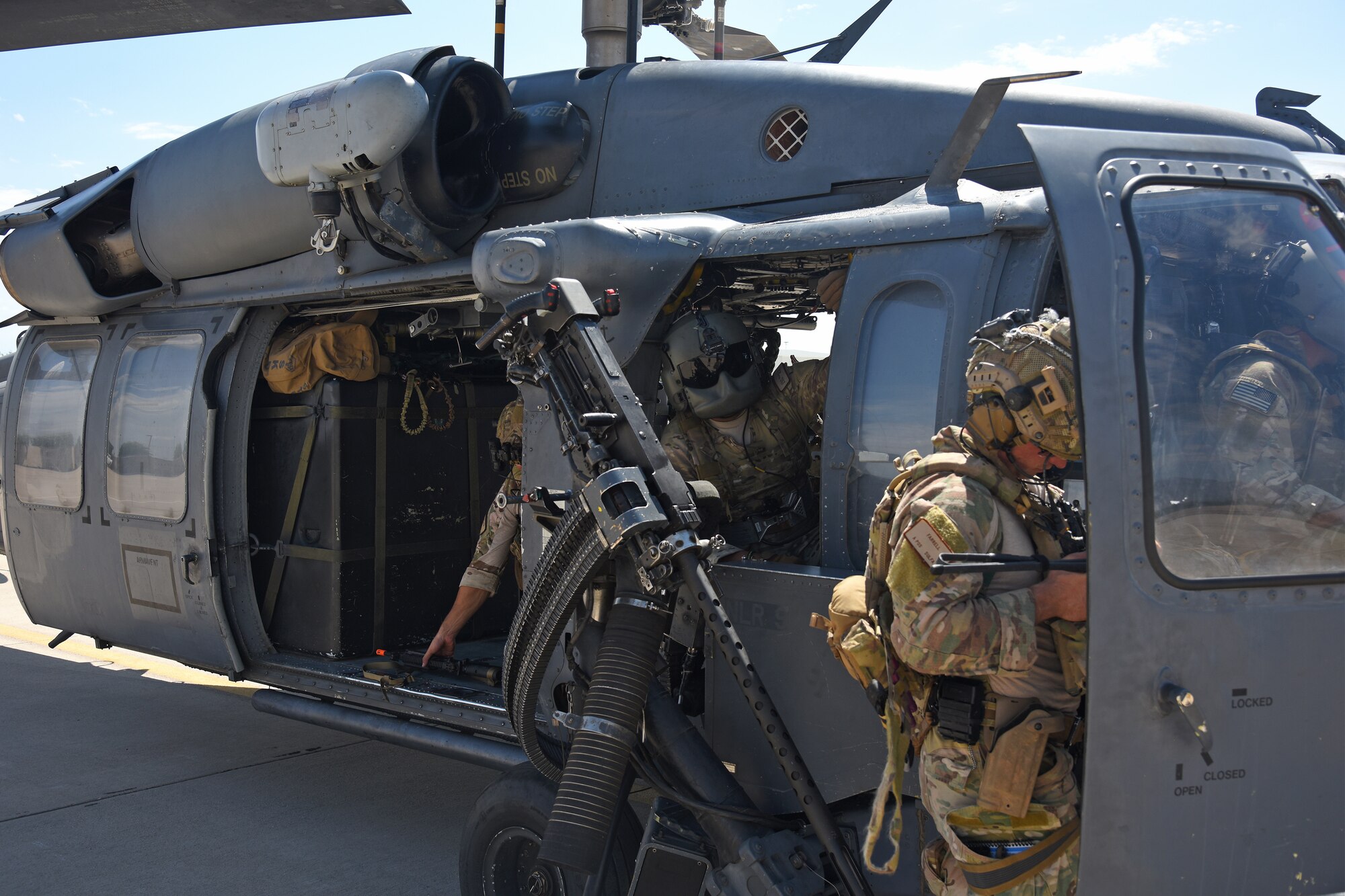 Photo of Air Force Airman inside an HH-60G Pavehawk on a military flightline