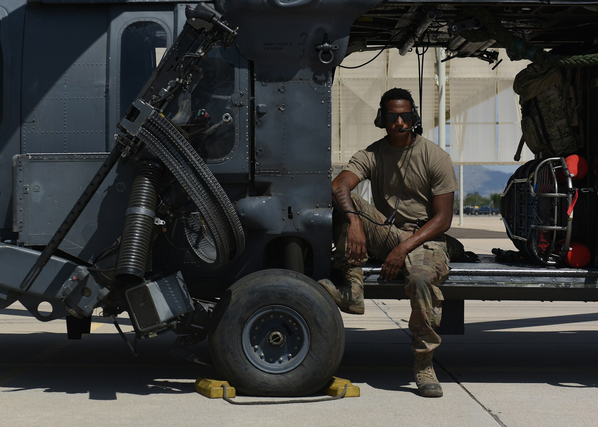 Photo of an Air Force Airman sitting in an HH-60G Pavehawk