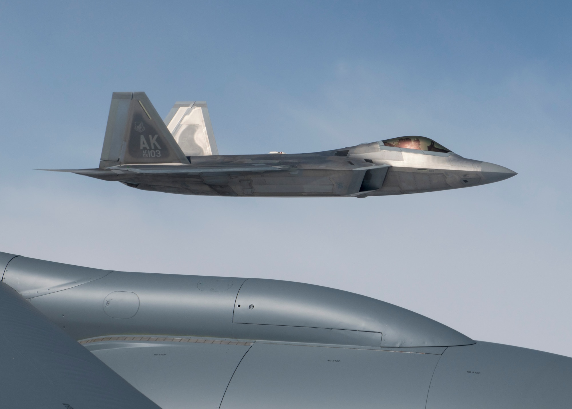 A U.S. Air Force F-22 Raptor from the 354th Fighter Wing flies in formation by a KC-135 Stratotanker from the 92nd Air Refueling Wing during field training exercise Red Flag Alaska 20-3, Aug. 4, 2020. RFA 20-3 is conducted over the Joint Pacific Alaska Range Complex with air operations flown primarily out of Eielson Air Force Base and Joint Base Elmendorf-Richardson, Alaska. (U.S. Air Force photo by Senior Airman Lawrence Sena)