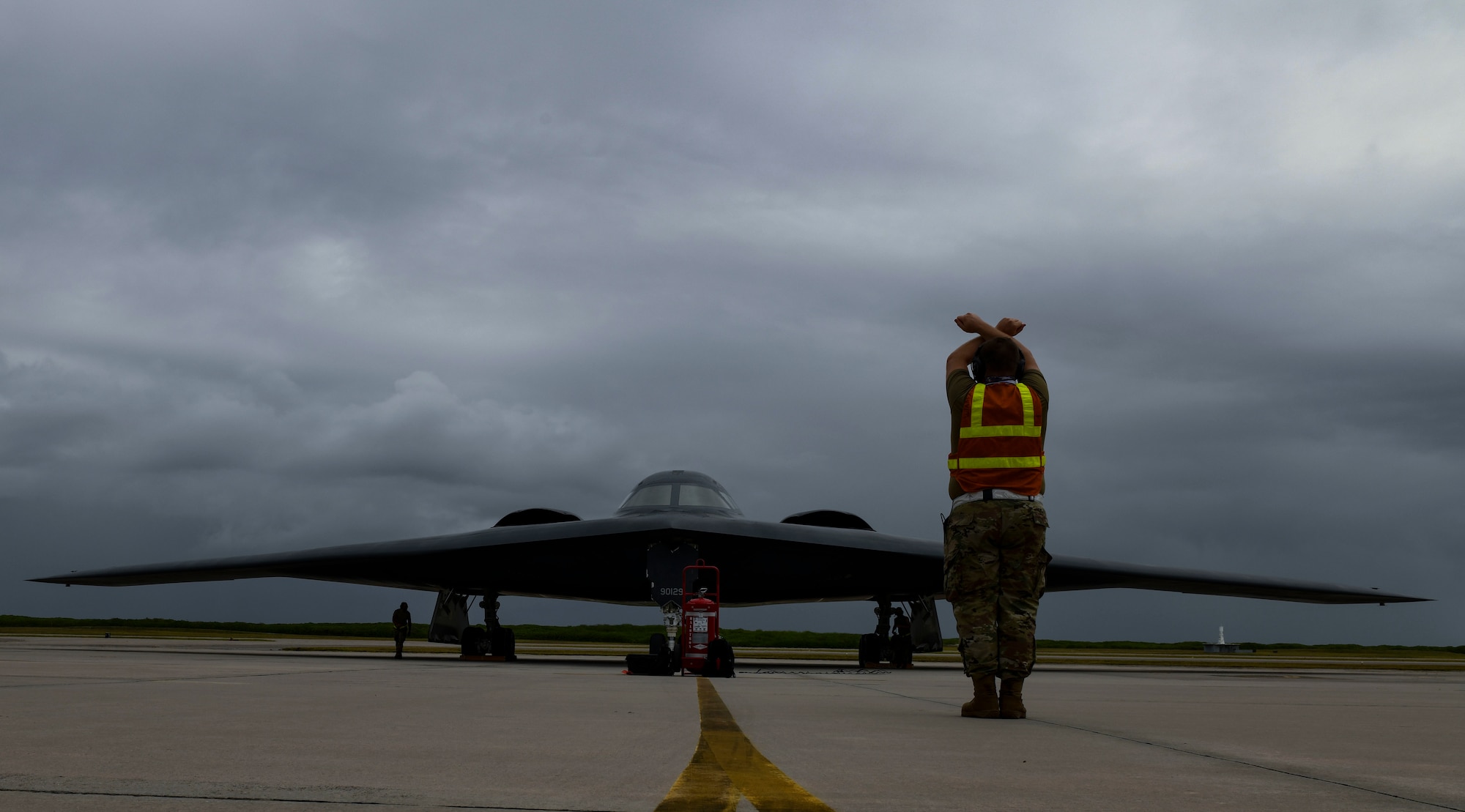 Staff Sgt. Mark Farrar, 131st Aircraft Maintenance Squadron crew chief stationed at Whiteman Air Force Base, Missouri, marshalls a B-2 Spirit Stealth Bomber as it arrives at Naval Support Facility Diego Garcia, Aug. 12, 2020. Three B-2 Spirits from Whiteman AFB deployed to NSF Diego Garcia to support U.S. security commitments in the Indo-Pacific region. (U.S. Air Force photo by Tech. Sgt. Heather Salazar)