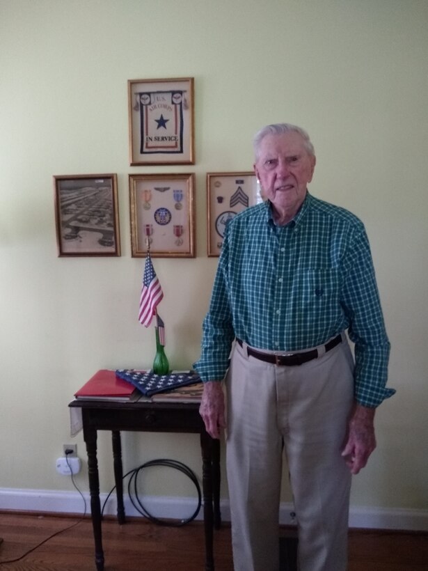 Man stands in front of patches and medals.