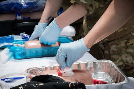 Airmen apply pressure to a prosthetic with a wound