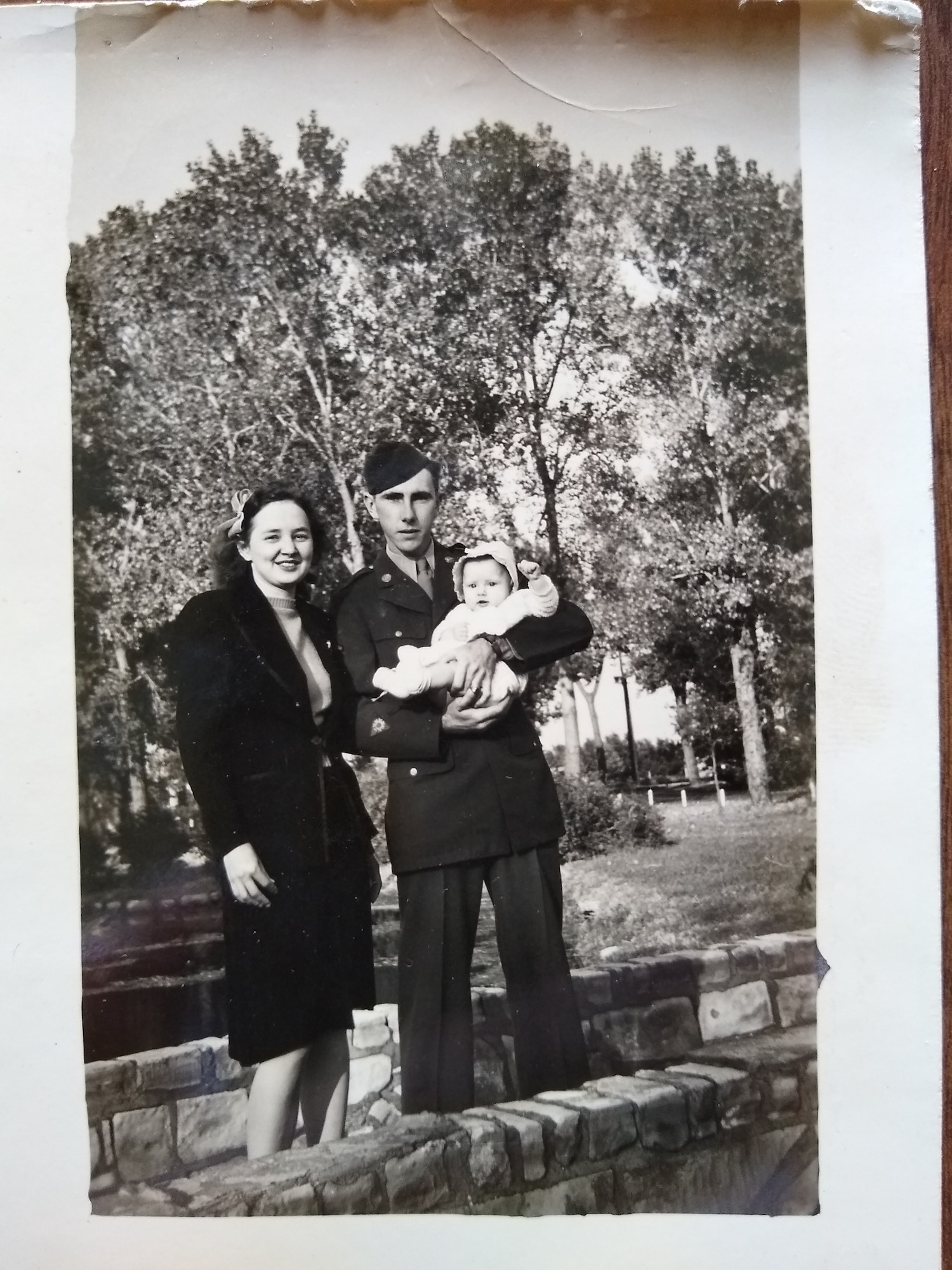 Man and woman stand holding a child.