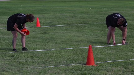 Sgt. Janina Felka-Burns, right, and Staff Sgt. Bronson Shipman, left, both master fitness trainers for the Kansas Army National Guard, show students with 1st Battalion, 161st Field Artillery Regiment, 130th Field Artillery Brigade, how to set up Army Combat Fitness Test Lanes. Students took part in a two-day training to become validated ACFT graders Aug. 4-5 in Salina, Kansas.