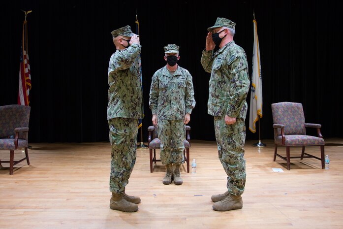 Capt. Peter Mirisola, left, salutes his relief, Capt. Christopher Gilbertson, right, during a change of command ceremony for Destroyer Squadron (DESRON) 50 and Commander, Task force (CTF) 55, presided over by Vice Adm. Jim Malloy, center, commander U.S. Naval Forces Central Command, U.S. 5th Fleet and Combined Maritime Forces, onboard Naval Support Activity Bahrain. DESRON 50 and CTF 55 operate in the U.S. 5th Fleet area of operations in support of naval operations to ensure maritime stability and security in the Central Region, connecting the Mediterranean and Pacific through the Western Indian Ocean and three critical chokepoints to the free flow of global commerce.