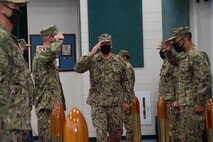 Capt. Christopher Gilbertson, the new commander of Destroyer Squadron (DESRON) 50 and Commander, Task force (CTF) 55, salutes the sideboys at the end of a change of command ceremony onboard Naval Support Activity Bahrain. DESRON 50 and CTF 55 operate in the U.S. 5th Fleet area of operations in support of naval operations to ensure maritime stability and security in the Central Region, connecting the Mediterranean and Pacific through the Western Indian Ocean and three critical chokepoints to the free flow of global commerce.