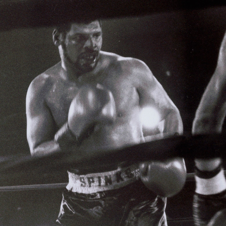 Men box during boxing match.