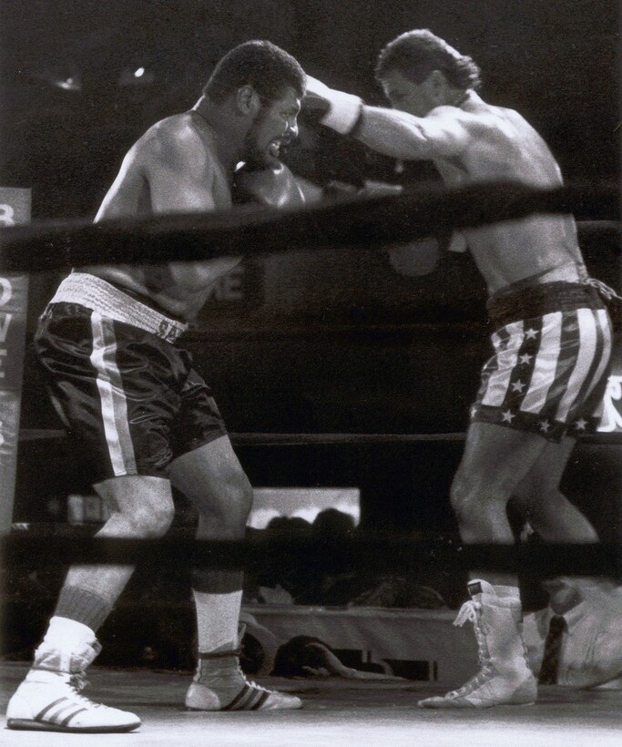 Men box during boxing match.
