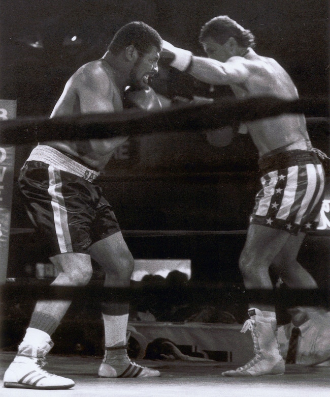 Men box during boxing match.