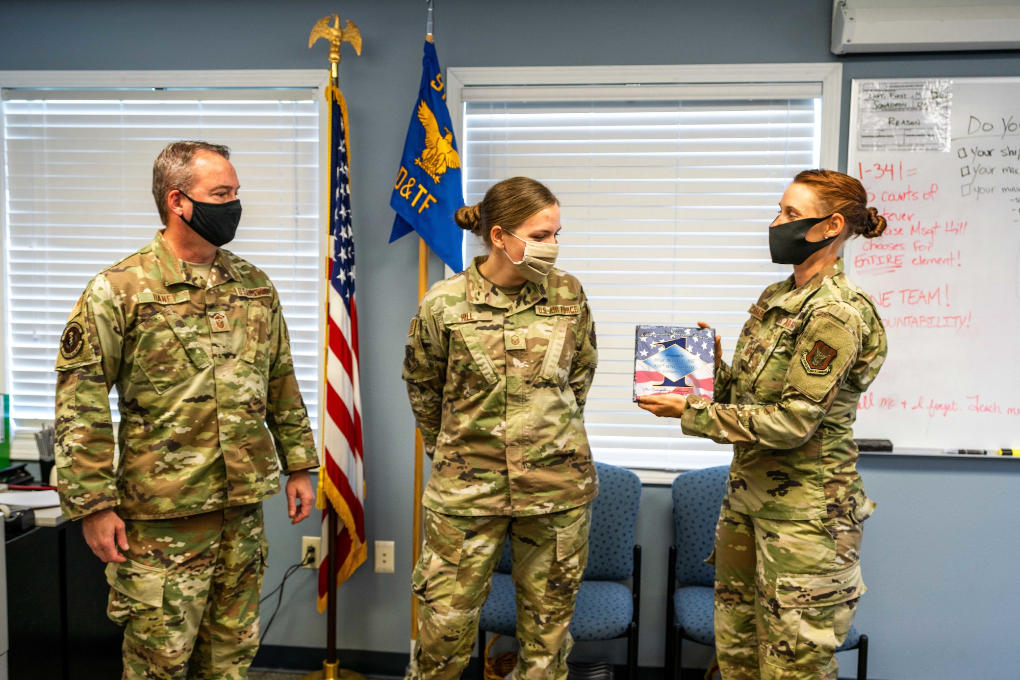 Airman receives award from two first sergeants.