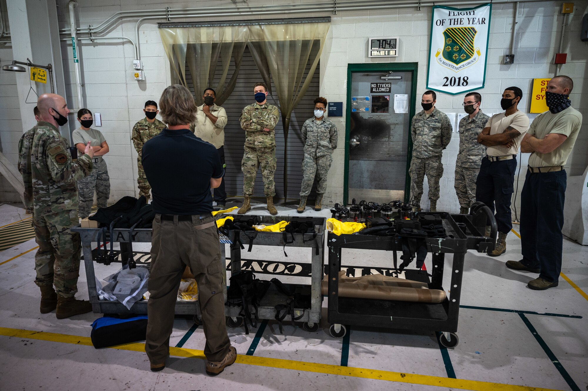 Airmen surround a table with equipment to learn how to use it.