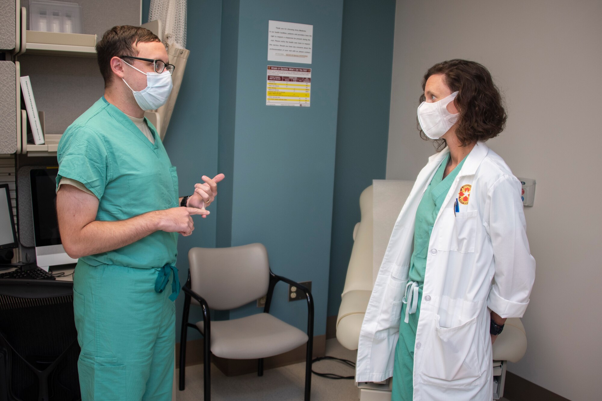 Image of U.S. Air Force Col. (Dr.) Heather Yun, Deputy Commander for Medical Services, talking with U.S. Air Force Capt. Joseph Marcus, senior infectious disease fellow.