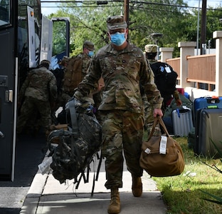 Soldier carrying bags from bus.