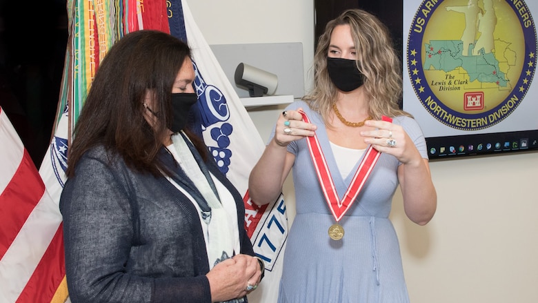 Patti Williams' daughter Cassi presents her with a De Fluery medal, the U.S. Army Engineer Association’s most prestigious award.