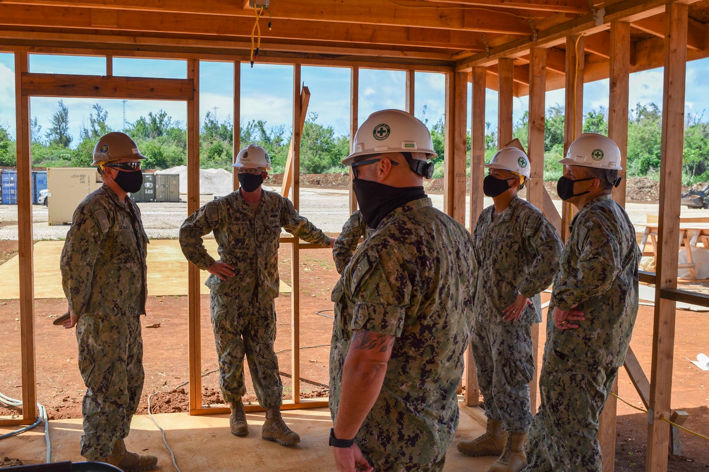 200810-N-HK244-1180 TINIAN, Commonwealth of the Northern Mariana Islands (Aug. 10, 2020) Builder 2nd Class Skylar Seagle, left, assigned to U.S. Naval Mobile Construction Battalion (NMCB) 3’s Detail Tinian, briefs Rear Adm. John Menoni, commander of Joint Region Marianas, right, on the progress of the construction of Camp Tinian. NMCB-3 is deployed across the Indo-Pacific region conducting high-quality construction to support U.S. and partner nations to strengthen partnerships, deter aggression, and enable expeditionary logistics and naval power projection. The battalion stands ready to complete assigned tasking, support Humanitarian Aid/Disaster Relief and Major Combat Operations throughout the area of responsibility. (U.S. Navy photo by Construction Electrician 3rd Class Constructionman Marcus Henley/Released)