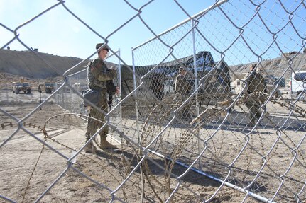 Colorado Army National Guard Spc. Tanner Burrows, 220th Military Police Company, guards the entrance to a mock detainment facility at the Montrose Training Facility, Montrose, Colorado, July 20, 2020. Soldiers from the 947th Engineer Company built the facility as part of annual training.