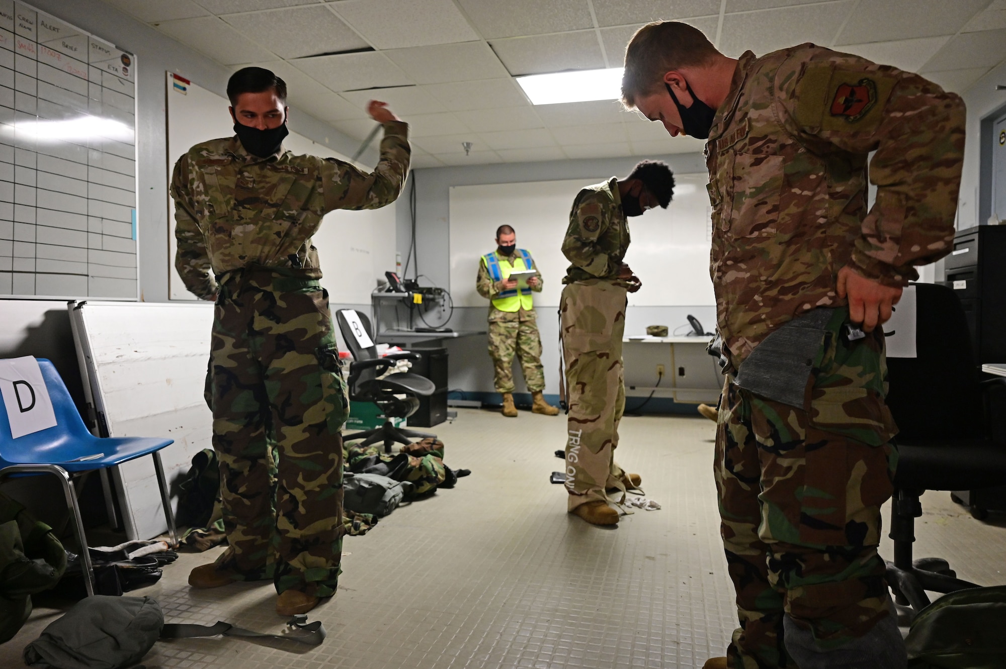 Airmen put on mopp gear during an exercise.