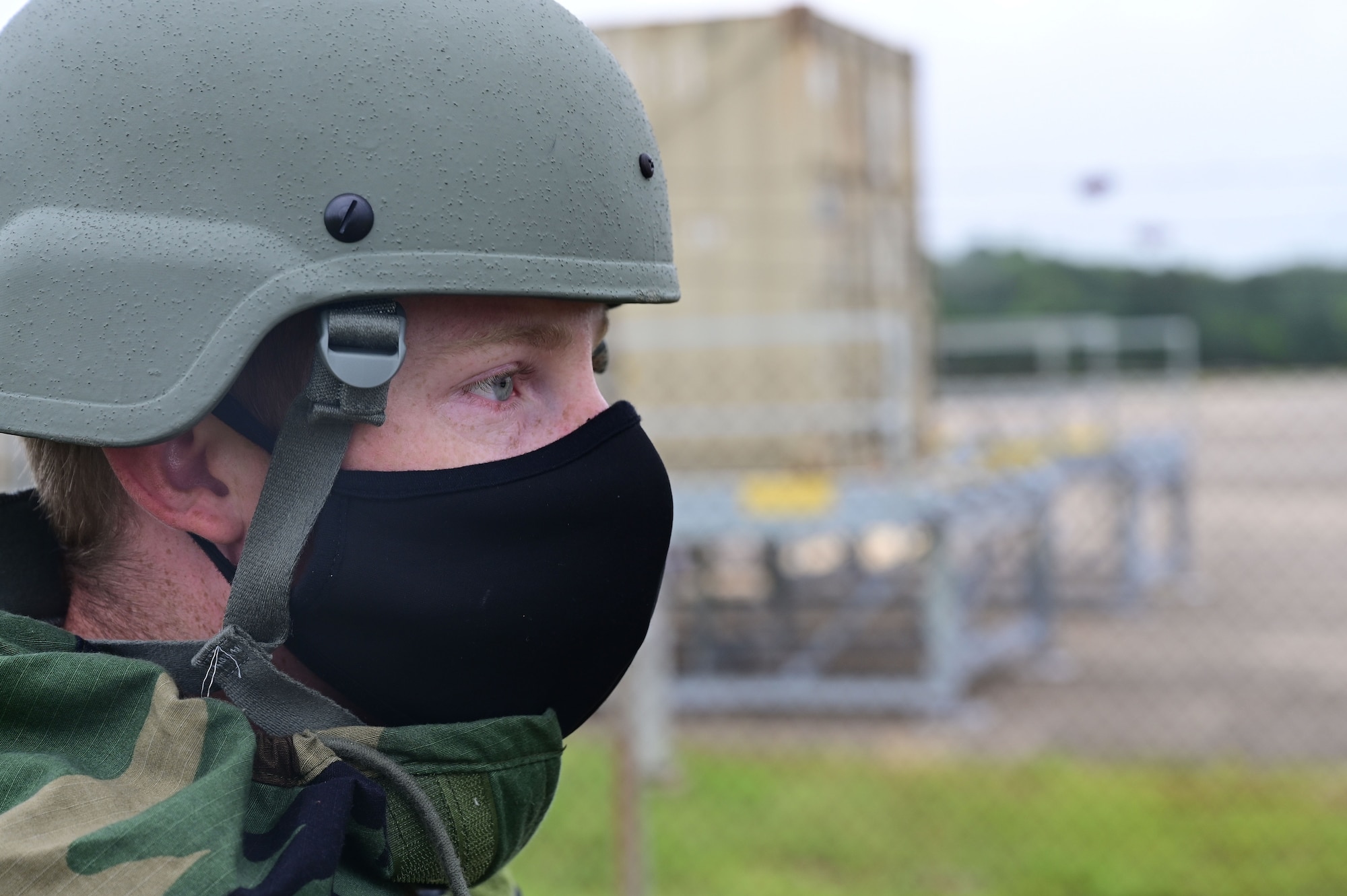 An Airman in a helmet looks off in the distance