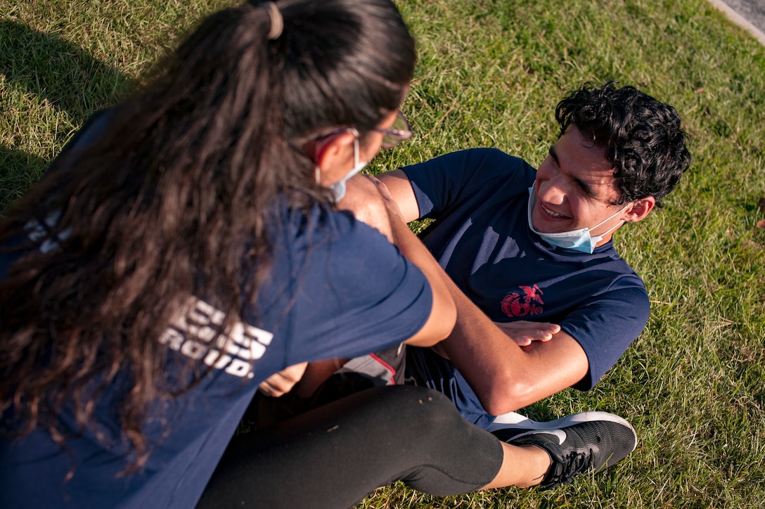 Poolee Mayra Cisneros counts crunches for her older brother Lazaro Cisneros as he conducts an Initial Strength Test July 18, 2020. Mayra Cisneros, 19, from Claxton, Georgia, and Lazaro Cisneros, 21, also from Claxton, are currently in the Delayed Entry Program with Recruiting Substation Statesboro, Recruiting Station Columbia, as they prepare for Marine Corps recruit training. (U.S. Marine Corps Photo by Sergeant Joseph Jacob)