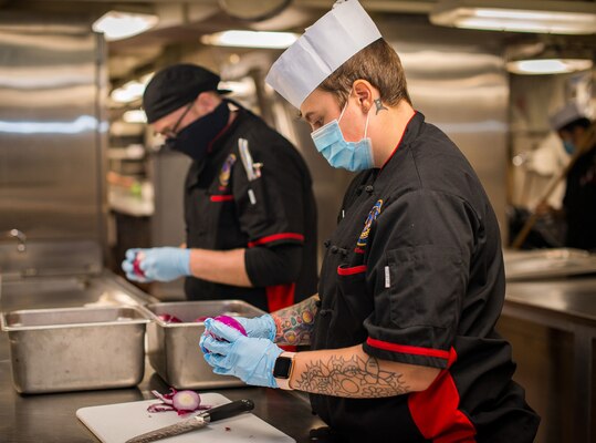 Culinary Specialist Seaman Katie Hobbs, from Columbus, Ohio, prepares dinner in the galley aboard the aircraft carrier USS Carl Vinson (CVN 70).