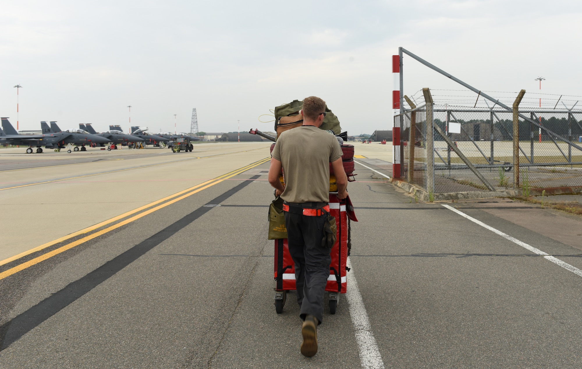 An Airman assigned to the 48th Aircraft Maintenance Squadron transports tools to the newly expanded F-15E parking ramp at Royal Air Force Lakenheath, England, Aug. 11, 2020. The ramp expansion facilitates construction of new infrastructure for the F-35A Lightning II arriving in late 2021. (U.S. Air Force photo by Airman 1st Class Rhonda Smith)