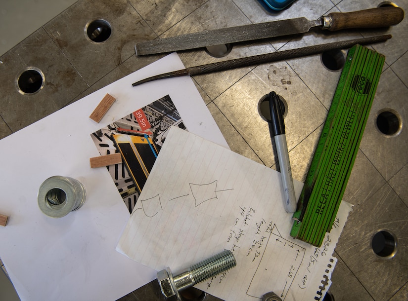 Tools and diagrams are displayed on a table.
