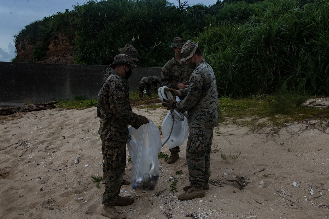 U.S. Marines clean the beach at Kin Blue, Okinawa, Japan, July 25.
